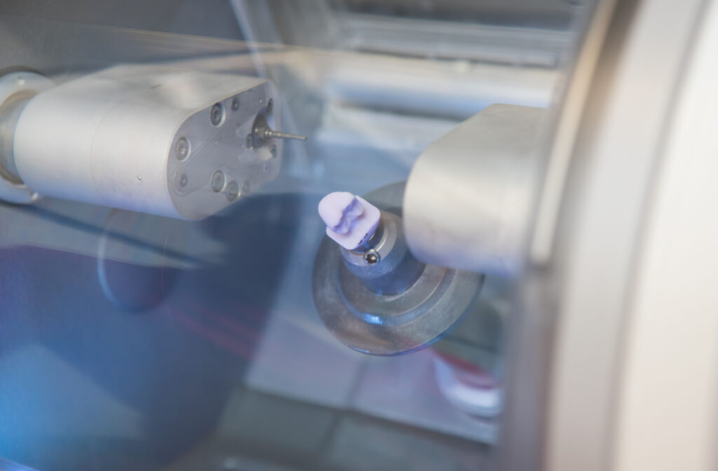 A close-up view of a finished dental implant in the CEREC dental milling machine in the doctor's office.