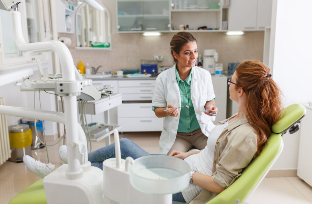 A dentist talking to her patient before examining her teeth.
