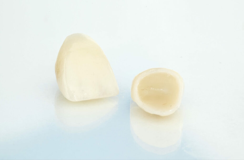 A close up of a pair of dental crowns against a white background.