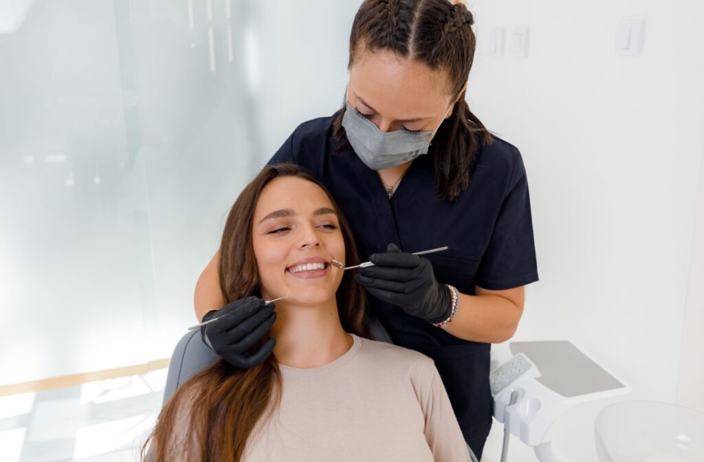 Dental hygienist examining a female patient during a routine dental check-up.
