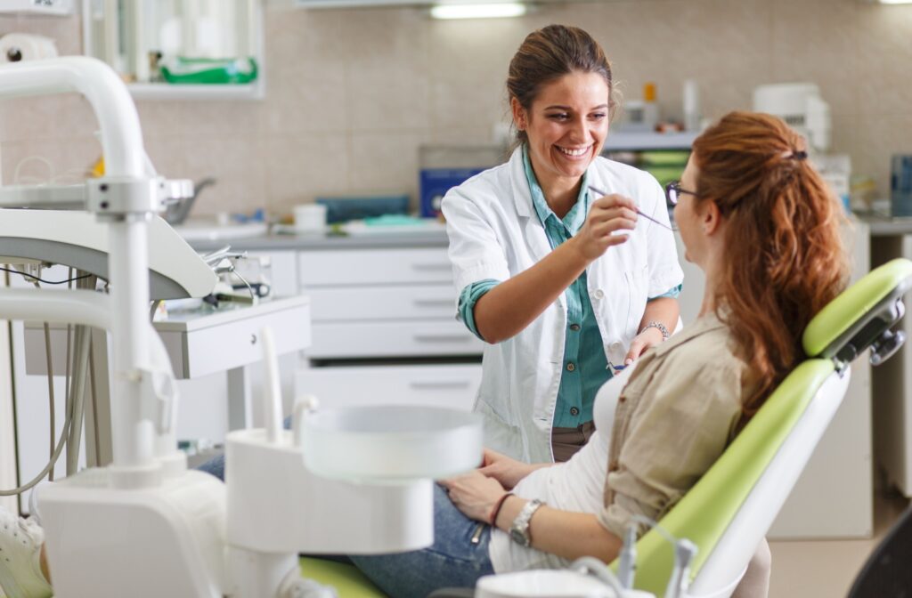Dentist interacting with a patient in a dental chair during a full dental exam.