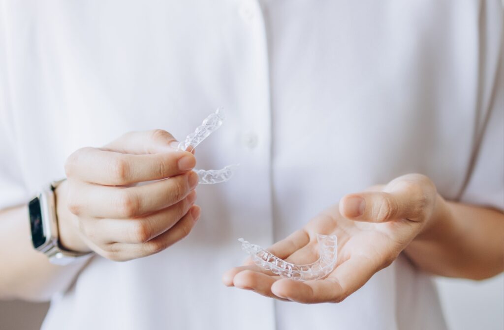 Two invisalign trays being held in a persons hands